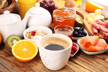 breakfast on table with bread buns, croissants, coffe and juice.