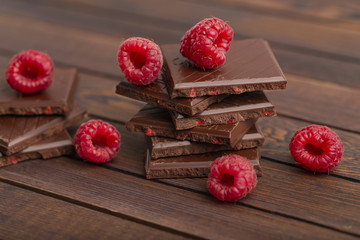 A stack of chocolate bars with built-in red raspberry berries. Fresh raspberries and chocolate on...