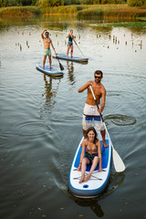 Man and women stand up paddleboarding