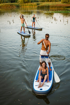 Man and women stand up paddleboarding