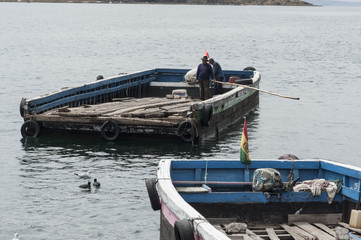 SAN PEDRO DE TIQUINA, BOLIVIA - AUGUST 18, 2017: Unidentified indigenous men on a river ferryboats on the shore of Lake Titicaca at the Strait of Tiquina in Bolivia - South America