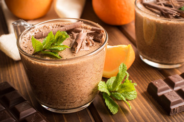 chocolate mousse dessert with orange on rustic wooden background.