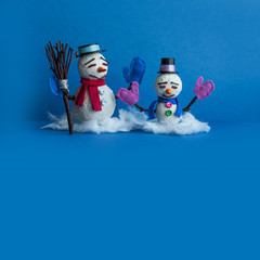 Two snowmen characters on blue background. Xmas New Year comical greeting card with funny snowman. Copy space
