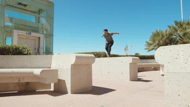 Man doing parkour free run jump training in city outside on sunny day