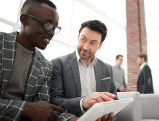 business colleagues use a digital tablet to view information