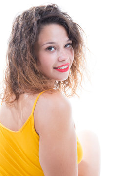 Portrait Of Young Curly Woman Wearing Yellow Top Against White Background