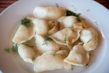 Vareniki with potatoes and fried bacon .