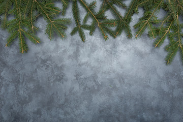 Holiday frame of Christmas decorations on blue dark stucco concrete background with fir branch, gold balls, stars, Christmas socks and toys. Elegant New Year`s snowy card. Top view.