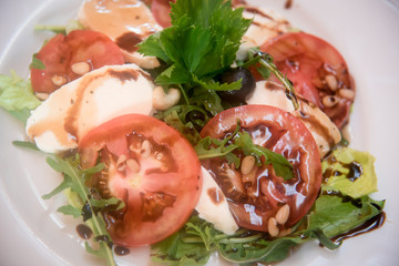 Fresh tomatoes with mozzarella, pine nuts and olives.