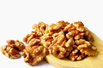 Closed up Heap of Walnuts on Wooden Spoon Isolated on White Background with Selective Focus 