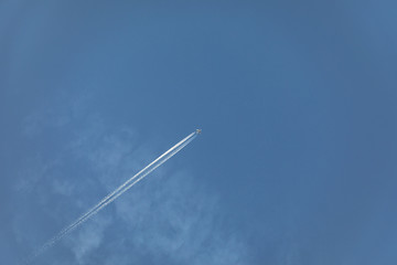 aircraft with contrail in morning sun