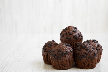 Chocolate muffins on white wooden background, side view. Close-up. Copy space.