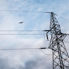 An airplane over a powerline - 223609801