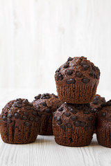 Chocolate muffins on white wooden surface, side view. Close-up.
