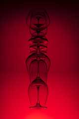 Obraz premium Inverted wine glasses on red background. Abstraction.