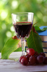 Red wine in a glass and bunch of grapes