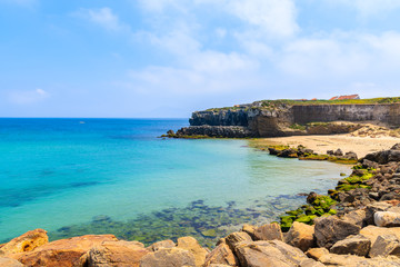 Rocks on sea coast and view of beach in Tarifa town, Costa de la Luz, Spain