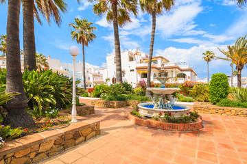 White houses and tropical palm trees in small coastal village near Marbella, Costa del Sol, Spain