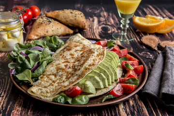 Breakfast omelet with avocado, tomato, mozzarella cheese, orange juice, samsa. Healthy food