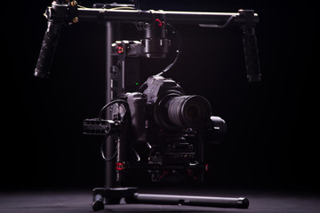Systems stabilization video camera and lens on steady equipment support such as gimbal steady or stabilized. Black background