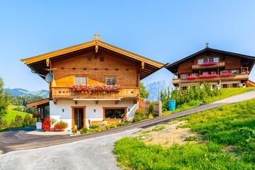 Fototapeta na wymiar Traditional houses on green meadow in Gieringer Weiher mountain area, Kitzbuhel Alps, Austria