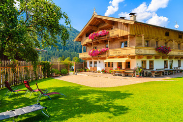 Fototapeta na wymiar Traditional wooden house decorated with flowers in small village near Kitzbuhel, Tirol, Austria