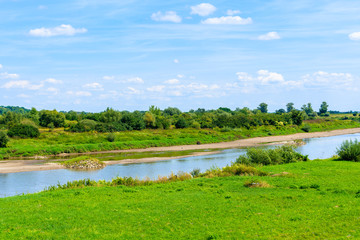View of Vistula river and green meadow near Cracow city on sunny summer day, Poland