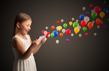 Cute little girl using tablet with colourful balloons concept

