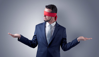 Covered eye, indecisive businessman standing blind in front of a wall