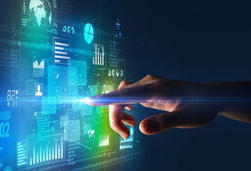 Female finger touching a beam of light surrounded by blue and green data and charts