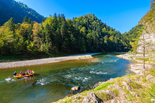 Raft with tourist on Dunajec river in autumn landscape of Pieniny Mountains, Poland