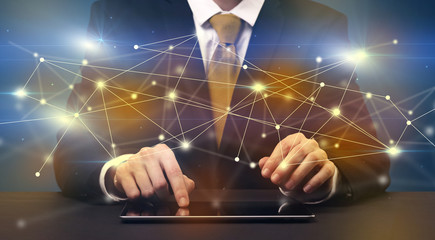 Businessman in suit typing with connection graphics around