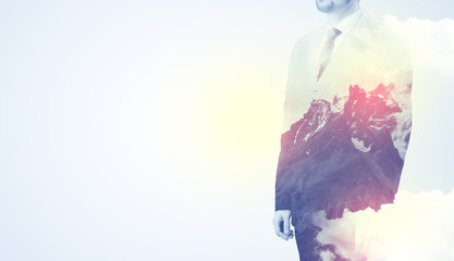 Businessman standing and thinking with snowy mountain graphic