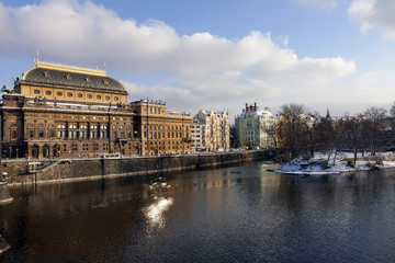 Fototapeta premium Snowy Prague National Theater above river Vltava, Czech Republic