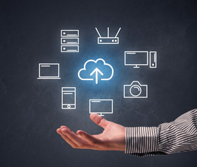 Cloud and computing related icons hovering over young hand 