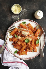 Pasta rigatoni in tomato sauce with chiken and parmesan cheese.Top view.