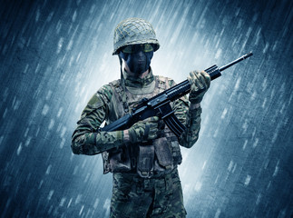 Armed soldier standing in rainy weather concept