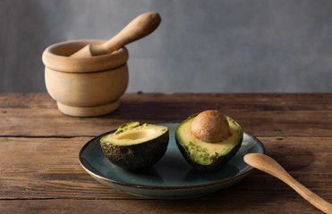 Avocado split in half on a blue plate