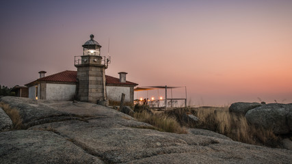 Fototapeta na wymiar Illuminated lighthouse over the sea and the coast of Galicia