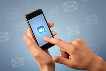 Female fingers touching smartphone with mail icon on it