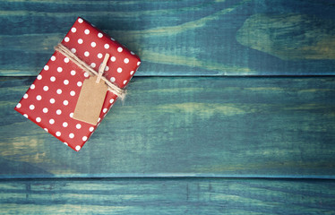 Obraz premium Single Wrapped Christmas Present with Gift Tag on a Wooden Table
