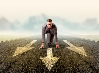 Young determined businessman kneeling before three arrows 