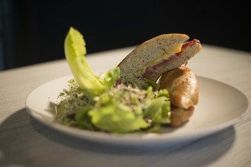 fried fish baguette with lemon and herbs on plate