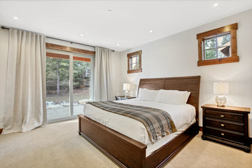 Bedroom interior with wooden bed and exit to back patio.