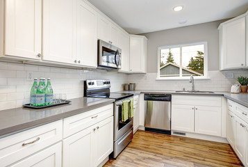 White and gray kitchen room with modern appliances.