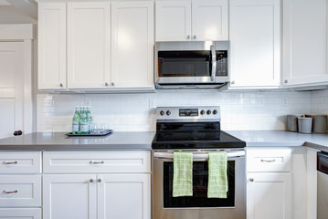 White and gray kitchen room with modern appliances.