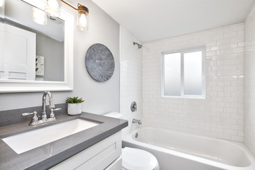Modern bathroom interior with white vanity topped with gray countertop - obrazy, fototapety, plakaty