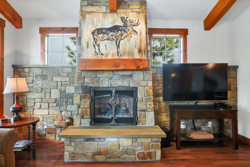 Living room interior with real stone fireplace and wooden beams.