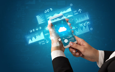 Female hand using smartphone with financial tracking concept illustrated by graphs and symbols
