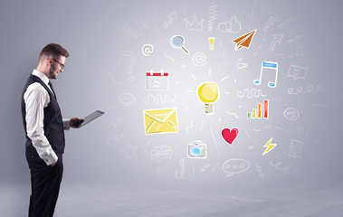 Young manager presenting new plan  illustrated by colourful chalk drawn icons and symbols around
